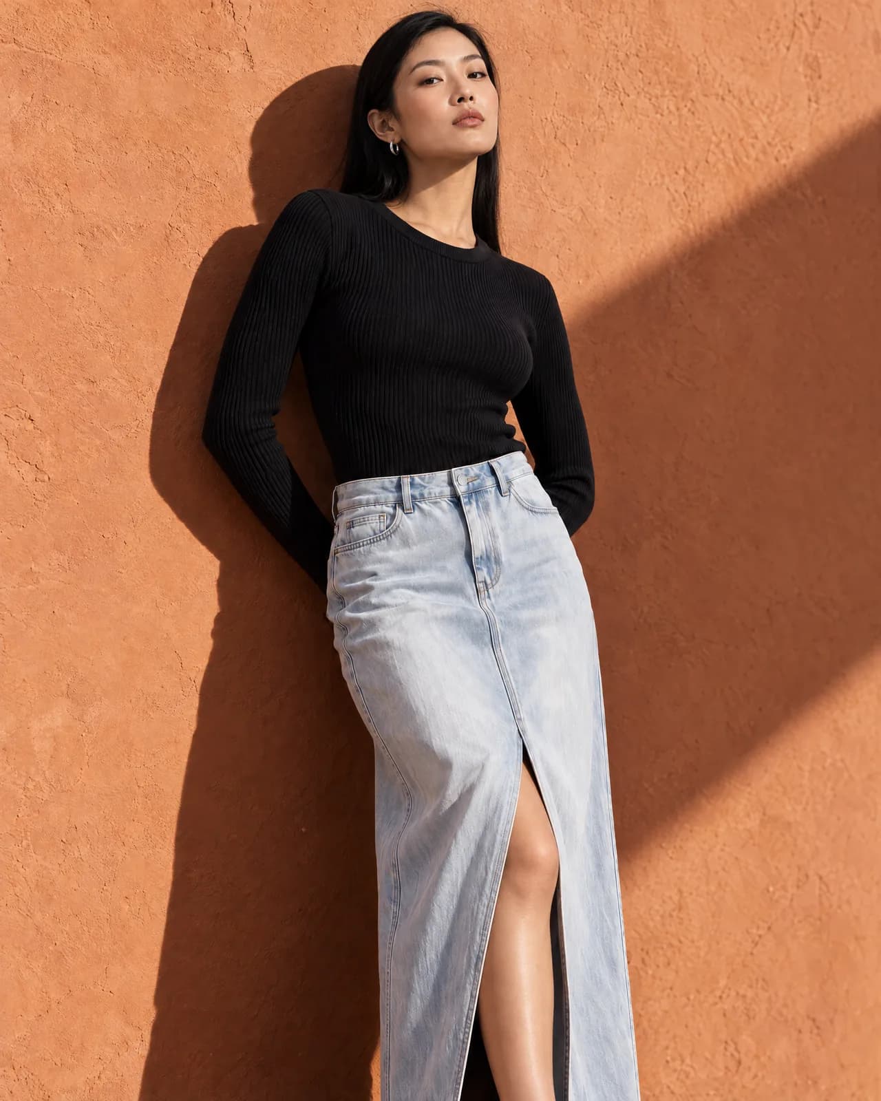 The same editorial shot of a knit top and denim maxi skirt on three different models.